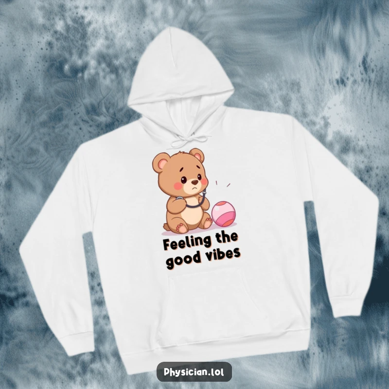 Funny hoodie design of a worried bear cub in a doctor's coat listening to a bouncy ball with a stethoscope, offering cozy humor.